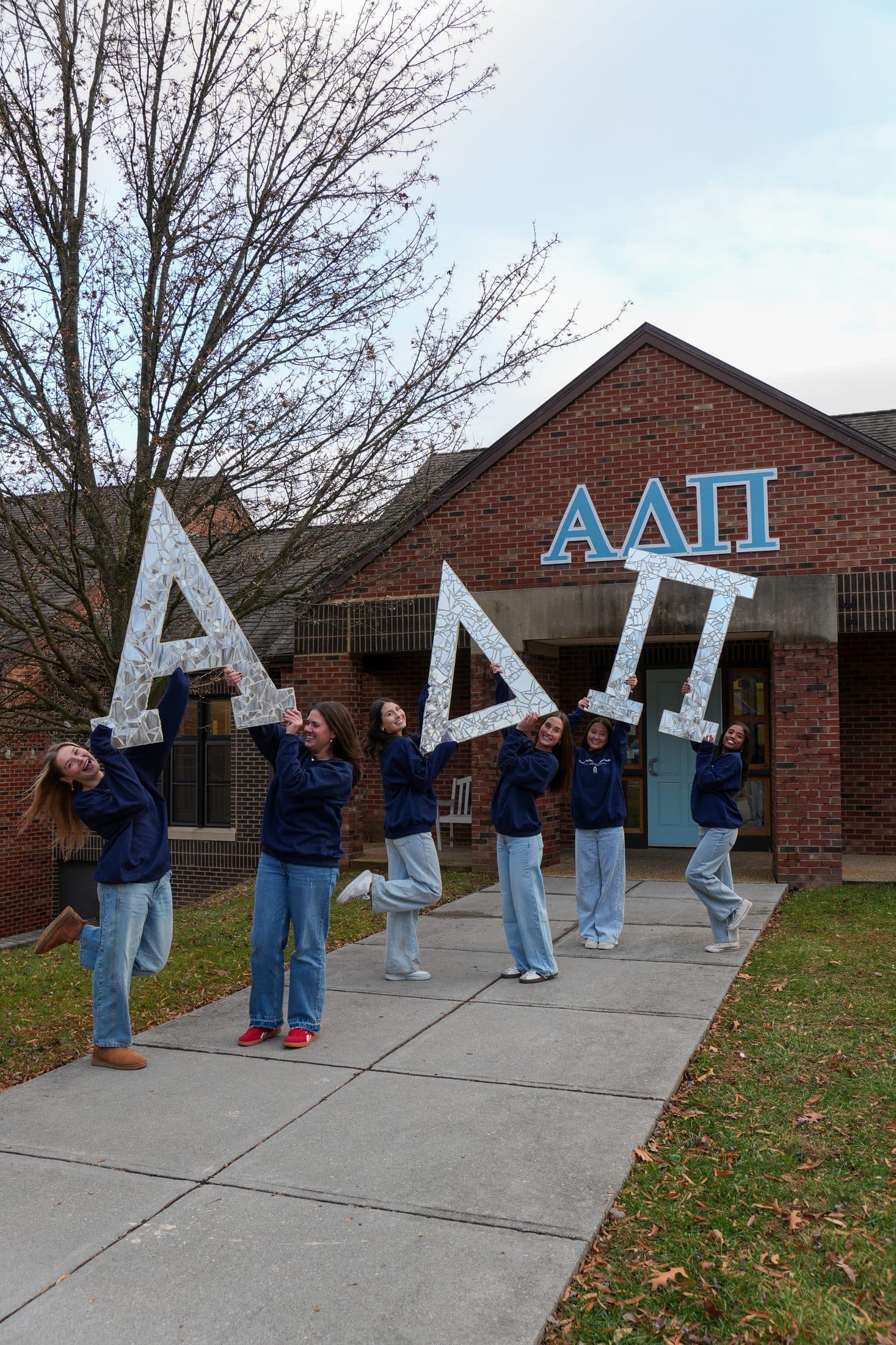 A sorority group holding up their painted Greek letters together