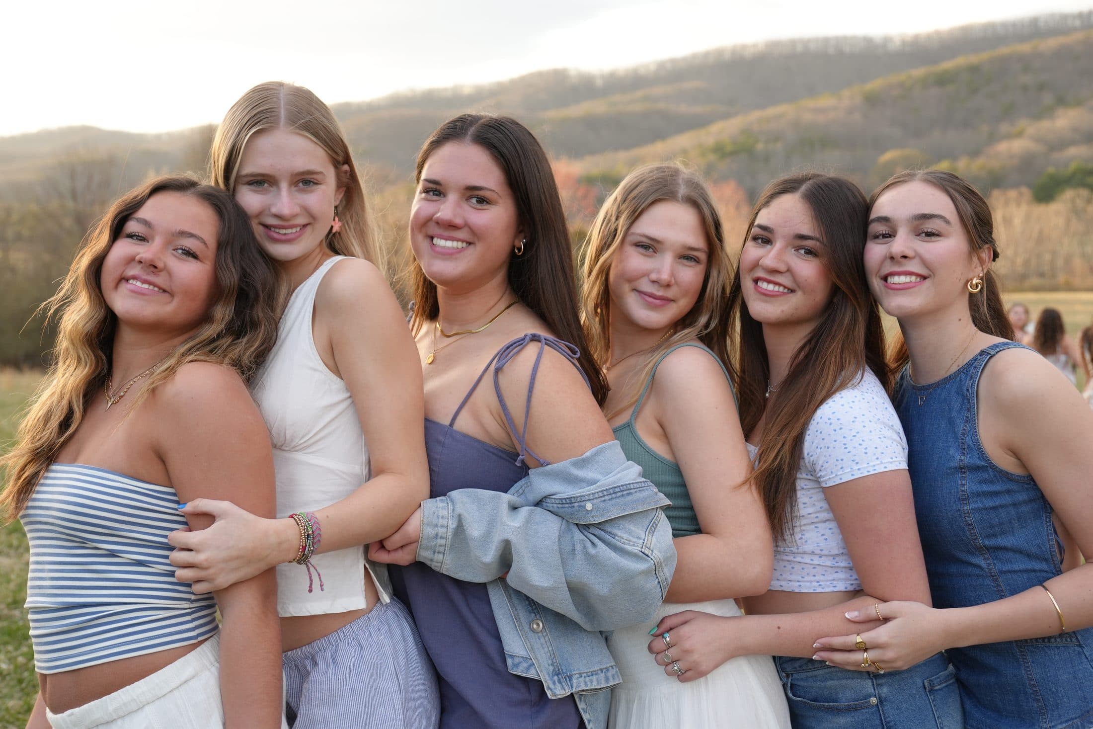 Friends laughing together in a field at golden hour